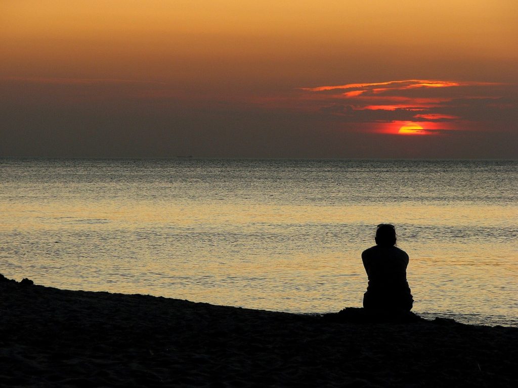 Person watching a sunset by the ocean